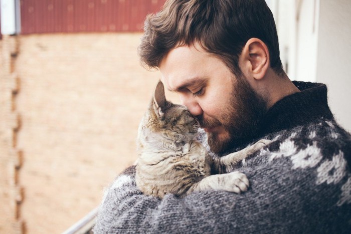 猫を抱き締める男性