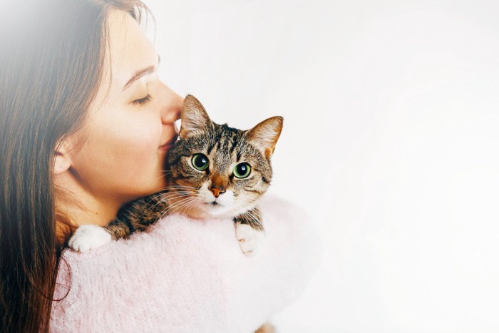 猫を抱いてキスする女性