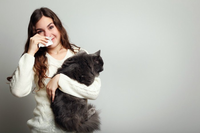 アレルギーのある女性に抱かれる猫
