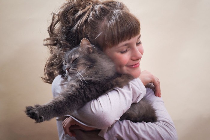 抱き合う猫と少女