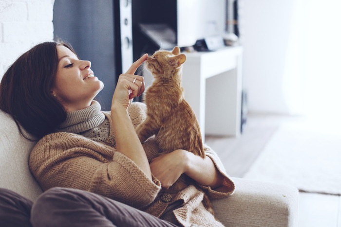 ソファーにいる女性と猫