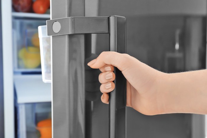 冷蔵庫の扉を閉める人の手