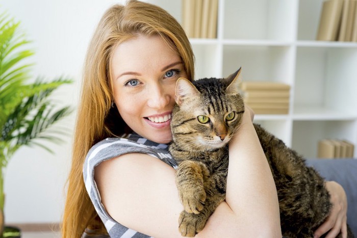 笑顔で猫を抱きしめる女性