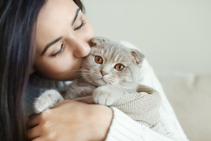 猫を抱きしめてキスをする女性