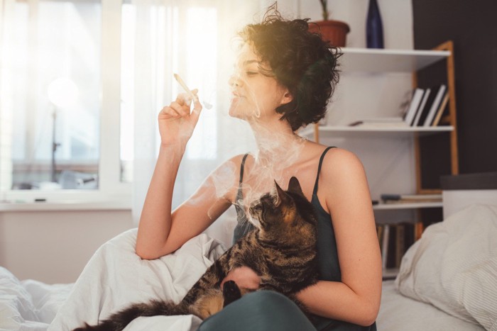 猫を抱えて喫煙する女性