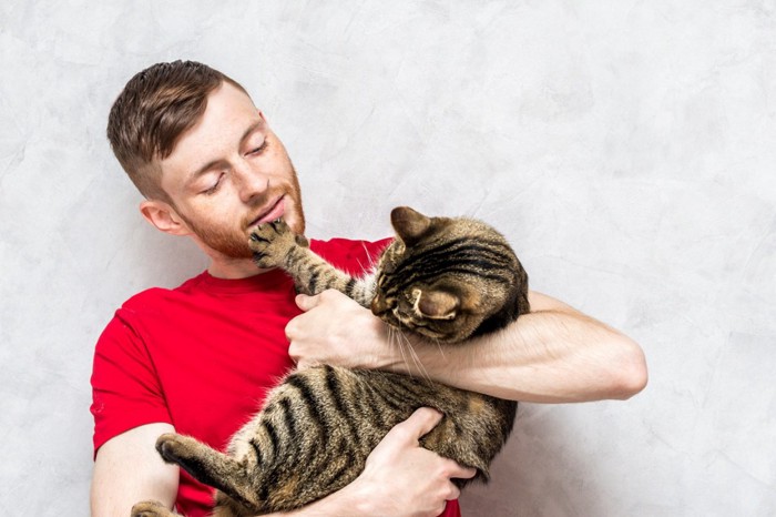 猫をしつこく抱っこする男性