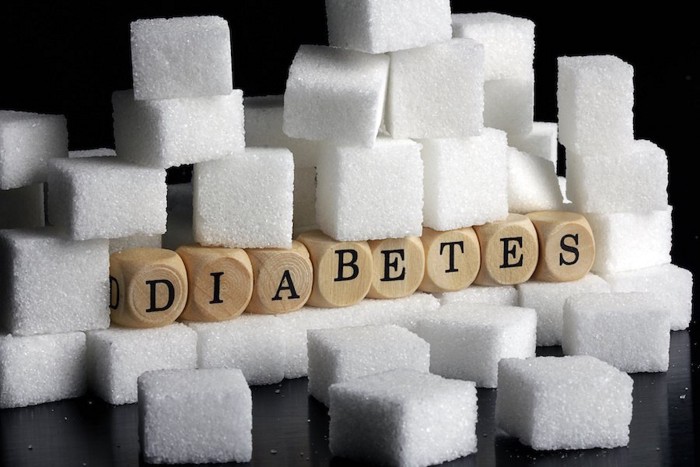 山積みにされた角砂糖と糖尿病の文字