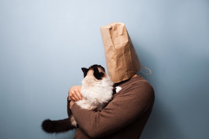紙袋を被った人と猫
