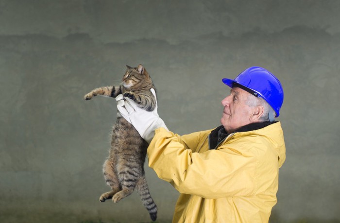 猫を抱きあげるおじいさん