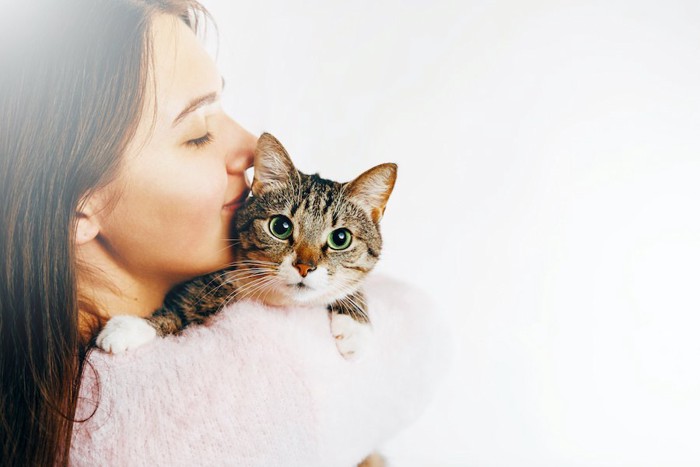猫を抱っこして顔を近づける女性