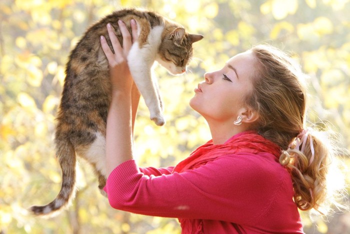 猫を抱き上げる女性