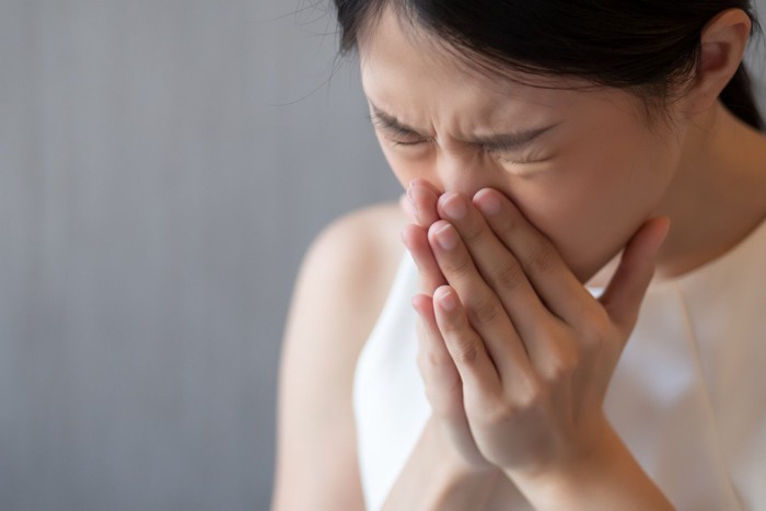 アレルギー反応によるくしゃみをする女性