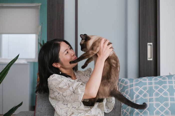 猫を抱っこする笑顔の女性
