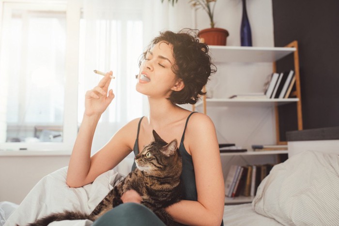 タバコを吸う女性と猫