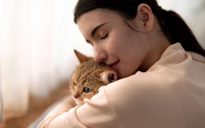 抱き合う猫と女性