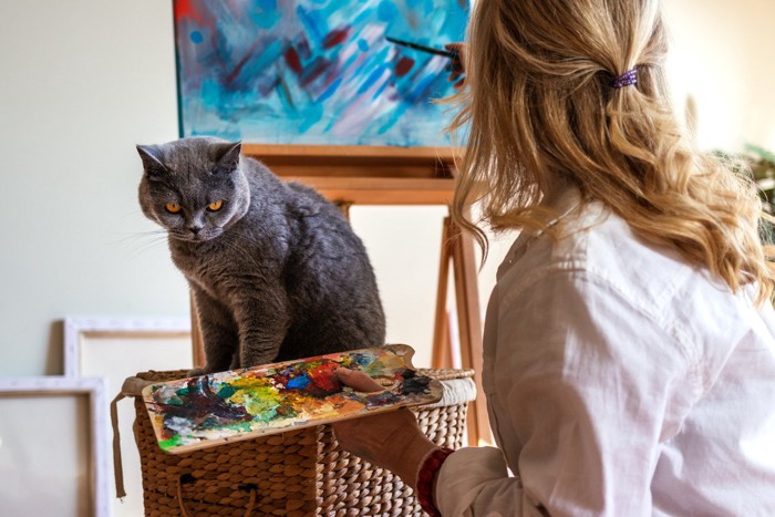 猫と絵を描く女性