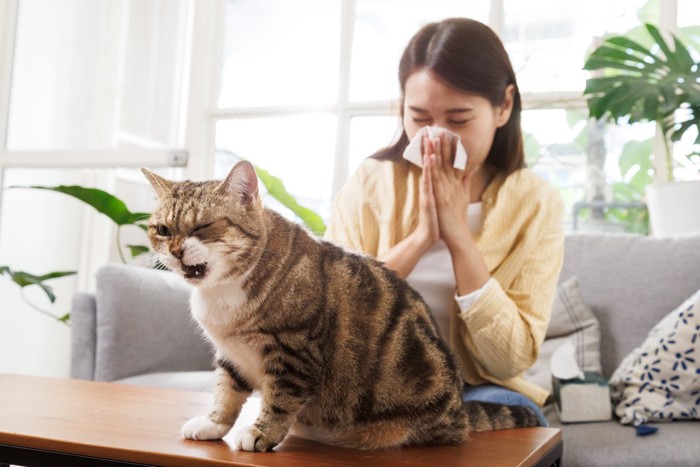咳こむ女性と猫