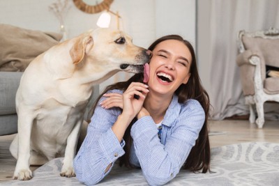 女性の頬を舐める犬