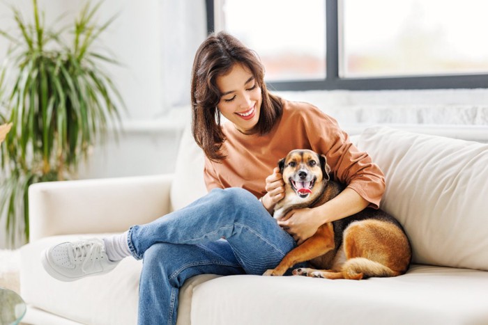 寄り添ってくつろぐ女性と犬