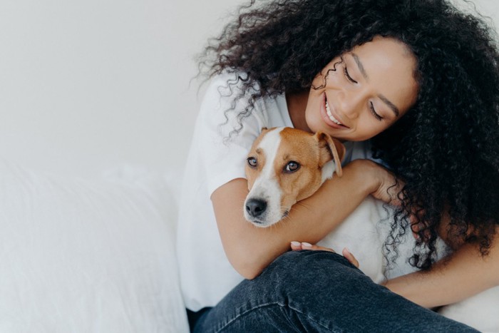 女性に抱きしめられる犬