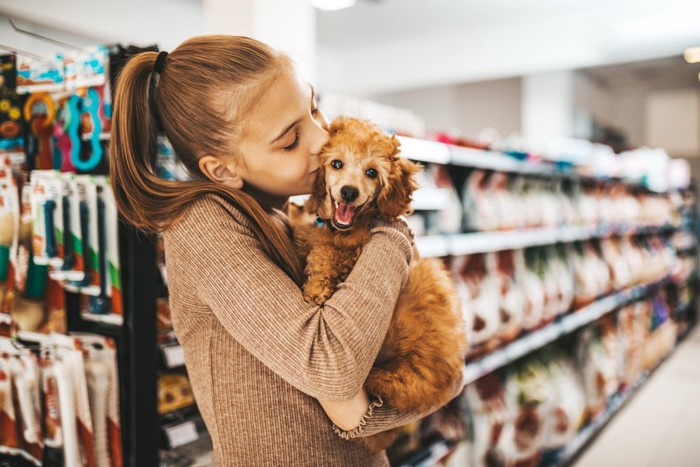 笑顔の犬にキスをする女性