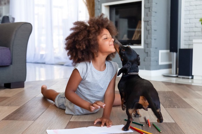 女の子の口元を舐める犬