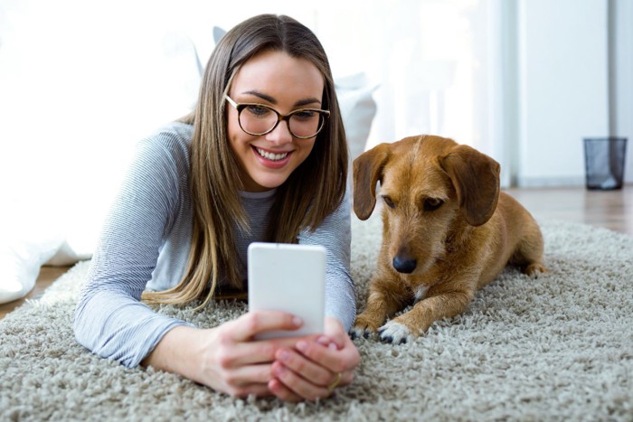 スマホをみる女性と犬