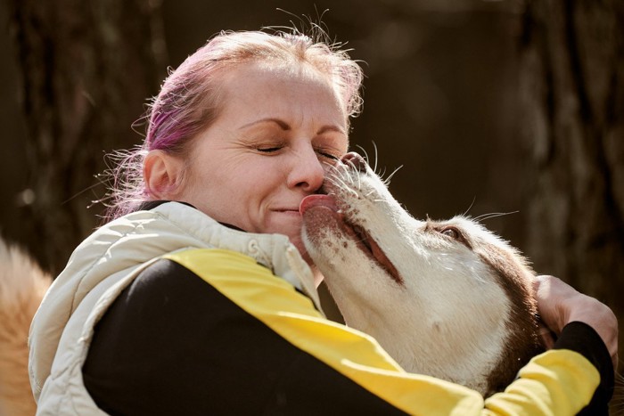 女性の口を舐める犬