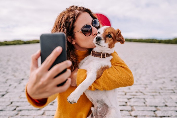 女性にキスされている犬