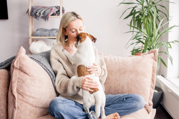 愛犬とキスする女性