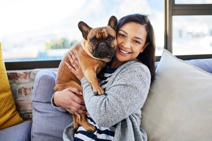 女性に抱かれていやそうな犬