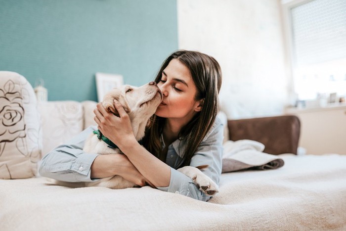 ベッドで寝る飼い主と犬 