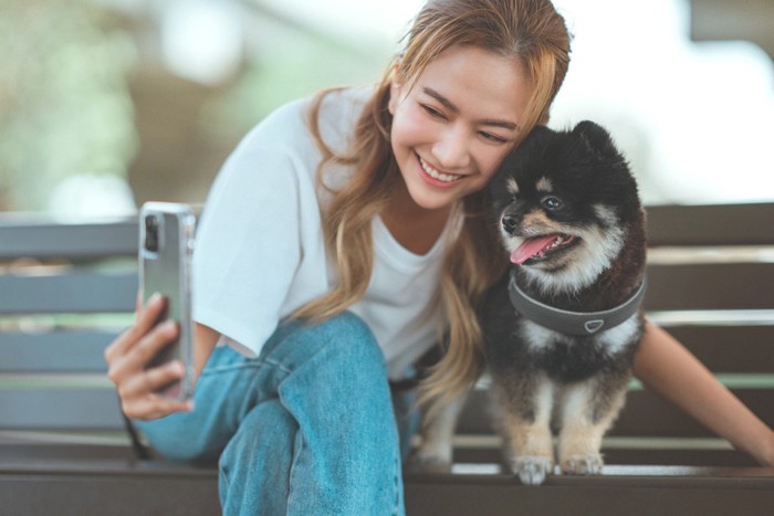 犬と一緒に写真を撮る女性