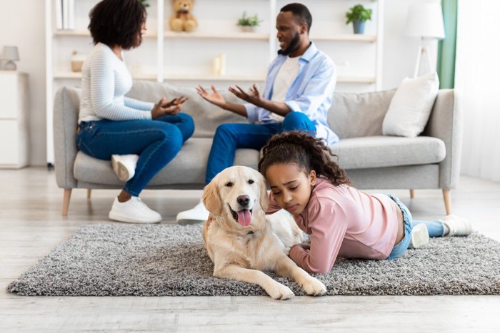 喧嘩中の家族のそばにいる犬