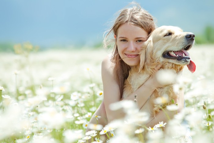 犬と女性と花