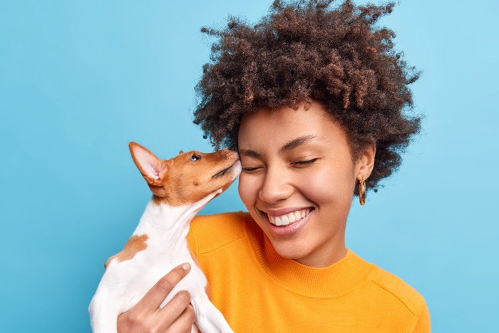 女性の髪を噛もうとする犬