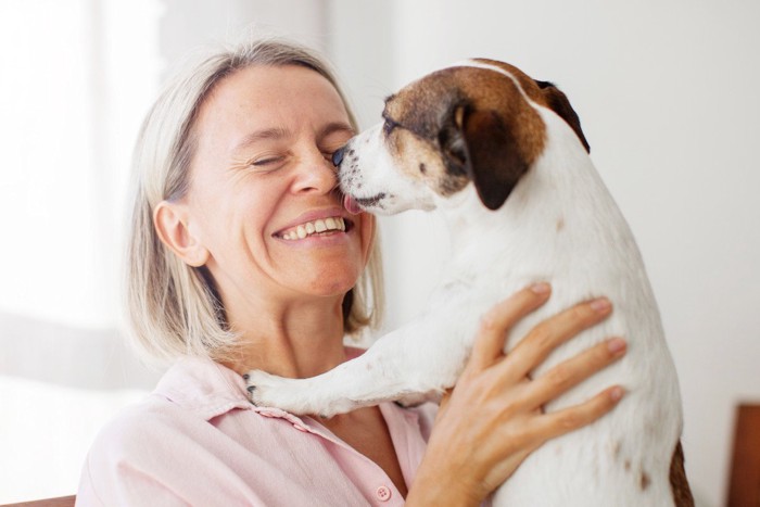 女性の顔を舐める犬