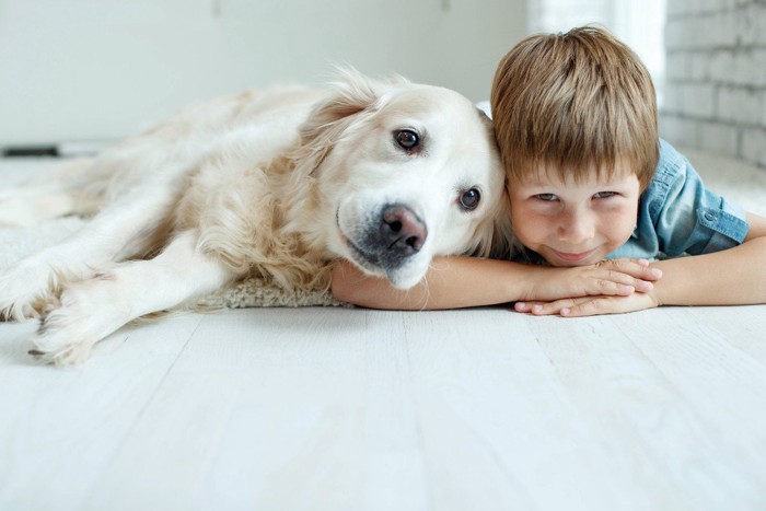 少年に寄りかかって笑顔の大型犬