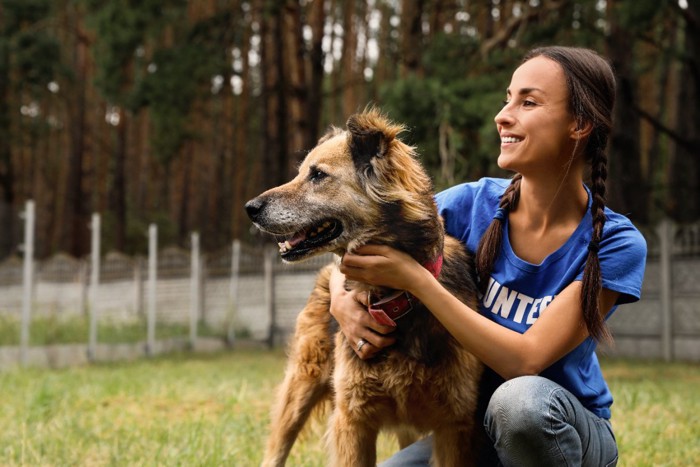 女性の側に座る犬