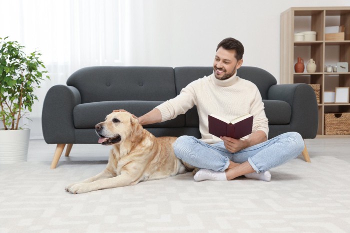 男性の隣に座る犬