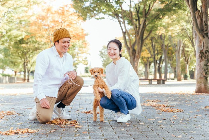 散歩中の犬と二人の人間