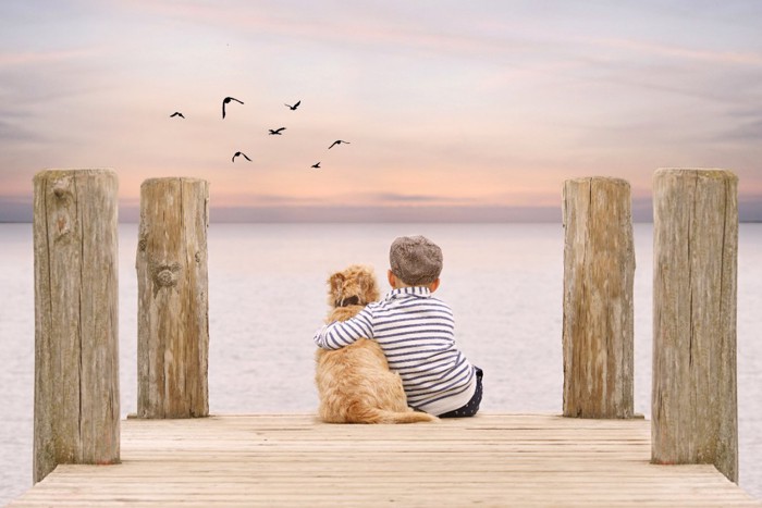 肩を抱く犬と子供