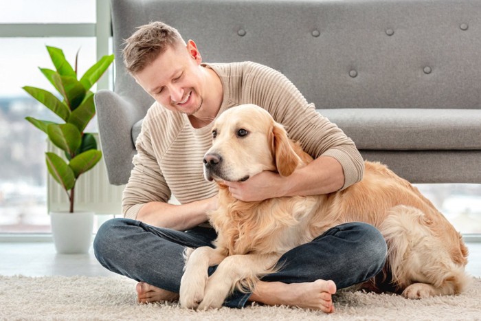 男性に撫でてもらう犬