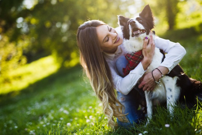 女性にハグされる犬