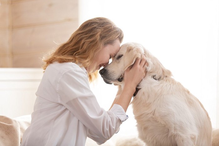 おでこを付け合う女性と犬