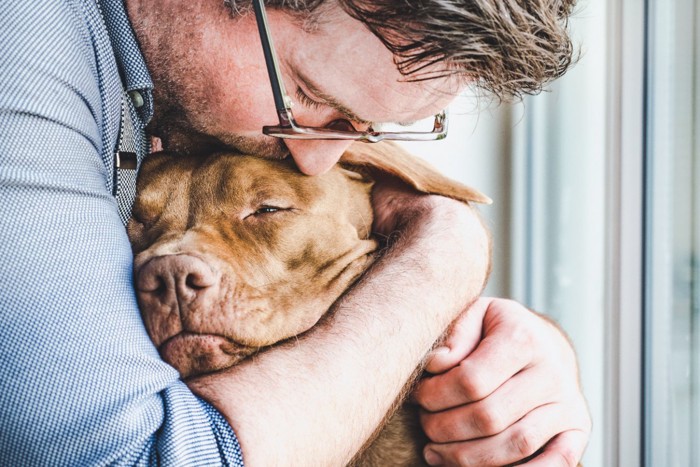 犬を抱きしめる男性