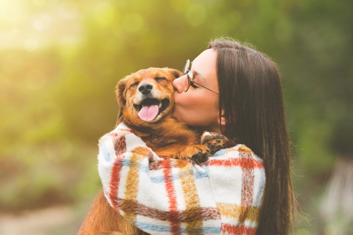 女性にキスされる犬