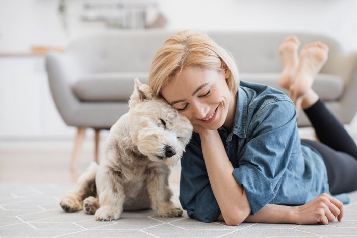 頭を寄せ合う犬と飼い主