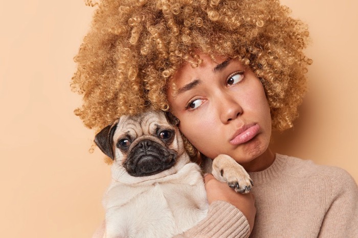 困った表情の女性と犬