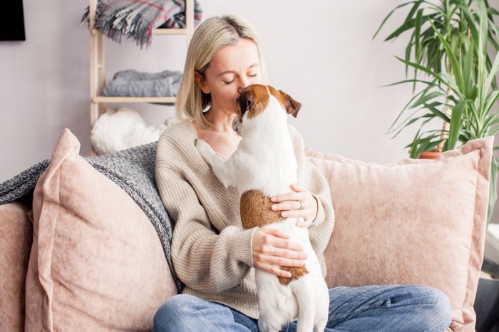 愛犬を抱き止める女性